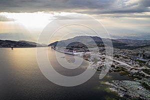 Landscape aerial drone view of Lagoa comprida lake and Marques da Silva dam in Serra da Estrela, Portugal at sunset