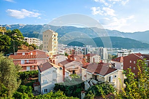 Landscape aerial view on roofs of old historical town of Budva and sea bay, mountains and forests of Montenegro, on background of