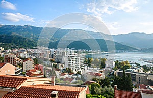 Landscape aerial view on roofs of old historical town of Budva and sea bay, mountains and forests of Montenegro, on background of