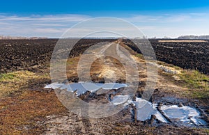 Landscape with agricultural fields and dirty road in central Ukraine