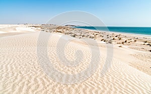 Landscape of Al Khaluf beach with dunes and white sands in the Arabian Sea of Oman