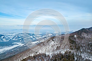 Landscape in the Altai mountains with snow-capped peaks under a blue sky with clouds in winter. White snow and calm