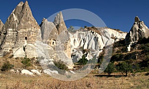 Amazing mountains with caves inside and snow-white rocks in the background in Zemi Valley near Goreme in Cappadocia