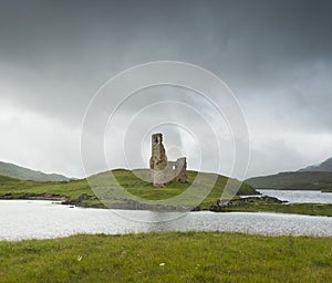 Landscape with ancient ruins of the small castle of Ardvreck in Scotland.