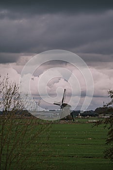 Landscape with ancient windmills in the Netherlands in gloomy spring weather. Stormy day over Dutch village of Streefkerk