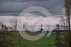 Landscape with ancient windmills in the Netherlands in gloomy spring weather. Stormy day over Dutch village of Streefkerk