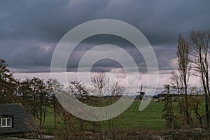 Landscape with ancient windmills in the Netherlands in gloomy spring weather. Stormy day over Dutch village of Streefkerk