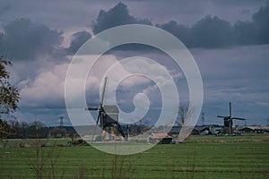 Landscape with ancient windmills in the Netherlands in gloomy spring weather. Stormy day over Dutch village of Streefkerk