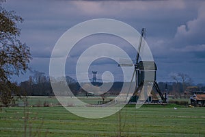 Landscape with ancient windmills in the Netherlands in gloomy spring weather. Stormy day over Dutch village of Streefkerk