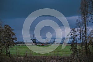 Landscape with ancient windmills in the Netherlands in gloomy spring weather. Stormy day over Dutch village of Streefkerk