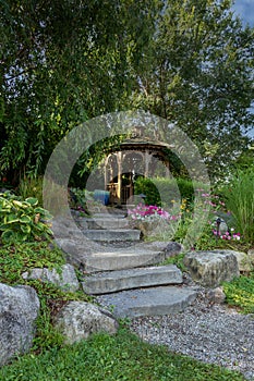 Landscape architecture with pink flowers and ornamental grasses for summer garden with water feature