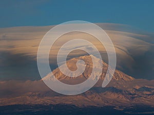 Landscape with the Arenal volcano which hangs over the lenticular cloud. Lenticular clouds above Kamchatka volcanoes at sunset