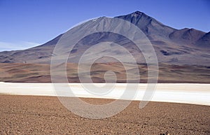 Landscape into the Atacama desert with a Volcano and a salt lake