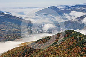 Landscape in autumn mountains. View from the top of the mountain on the forest fog coatings.