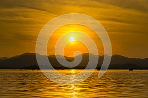 The landscape Background of a golden sunset reflect water and silhouette mountain in west lake xihu in Hangzhou CHINA