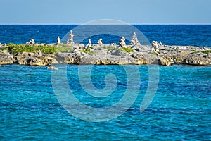 Landscape with balanced rocks, stones on a rocky coral pier. Turquiose blue Caribbean sea water. Riviera Maya, Cancun, Mexico.