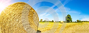 Landscape banner wide panoramic panorama background - Hay bales on a field and blue sky and apple tree in the summer in Germany