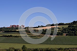 Landscape in Bavaria with green fields and meadows against a blue sky. Harburg Castle stands in the sun on a gentle hill