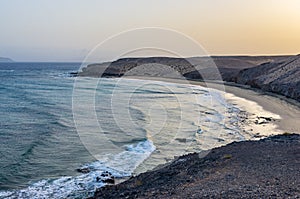 Landscape of a beach with a sailboat crossing the horizon