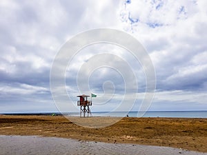 Landscape of beach and sea with lifeguard post and green vandera allowing the bath. Canary Islands, Spain