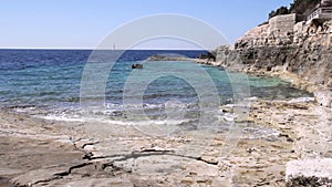 Landscape of beach with waves crashing on coral rock in Istria, Croatia. Waves breaking on stony beach, forming a spray.