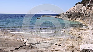 Landscape of beach with waves crashing on coral rock in Istria, Croatia. Waves breaking on stony beach, forming a spray.