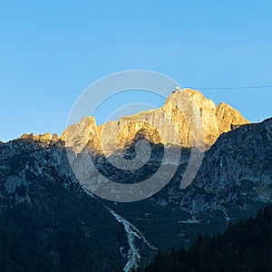 Landscape of a beautiful alpine mountain range covered in greenery on a sunny day
