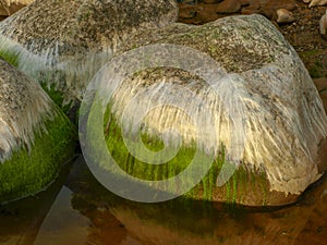 Beautiful rocks by the sea, colorful reflections in the water