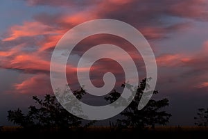 Landscape of beautiful sky with clouds at October sunset. Small moon..