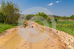 Landscape with big puddle on an earth road