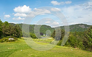 Landscape on Bjaavann golf course with green grass, trees, beautiful blue sky, panorama