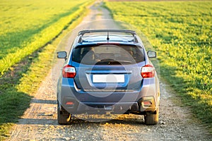 Landscape with blue off road car on gravel road. Traveling by auto, adventure in wildlife, expedition or extreme travel on a SUV