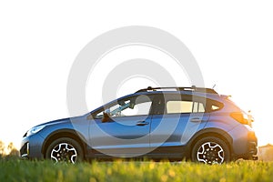 Landscape with blue off road car on green grass. Traveling by auto, adventure in wildlife, expedition or extreme travel on a SUV