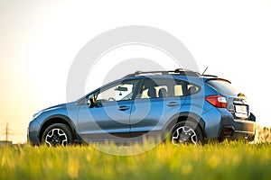 Landscape with blue off road car on green grass. Traveling by auto, adventure in wildlife, expedition or extreme travel on a SUV