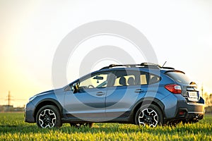 Landscape with blue off road car on green grass. Traveling by auto, adventure in wildlife, expedition or extreme travel on a SUV