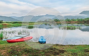 Landscape boat on the lake reflects a blue sky. The cloudy sky is reflected in the mirror like smooth lake surface.