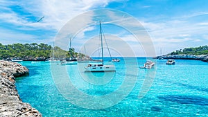 Landscape with boats and turquoise sea water in Cala Mondrago, Majorca island, Spain