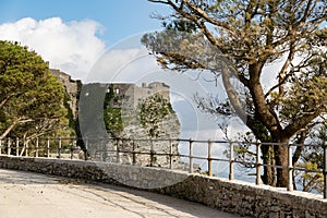 The landscape with Castello di Venere in Erice, Sicily, Italy and rocky mountain Monte Erice with tree and road in the foreground