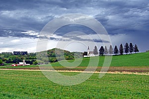 Landscape with a chapel and scenic trees in the countryside on a moody day
