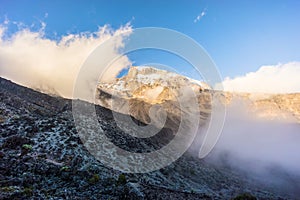 Landscape of the cloudy peak of Mount Kilimanjaro under sunlight and shadow