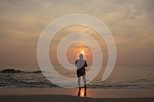 Landscape of cloudy sky and sea that has fisherman who hold fishnet stand on the beach in morning