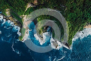 Landscape with coastline, rocks and blue ocean with waves in Indonesia. Aerial view