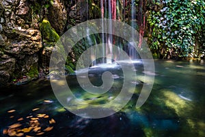 Landscape of colorful flowing waterfall on turquoise water in Argiroupoli, Greece