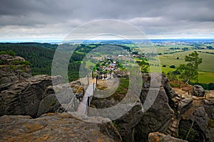 Landscape of Czech Republic. Rocky hill above small village. Stones with ferrous trail. Summer view of beautiful area Drabske