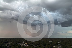 Landscape of dark ominous clouds forming on stormy sky before heavy thunderstorm over rural town area