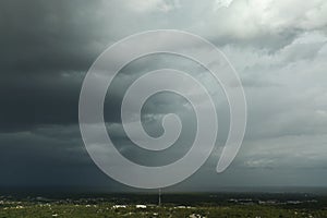 Landscape of dark ominous clouds forming on stormy sky before heavy thunderstorm over rural town area