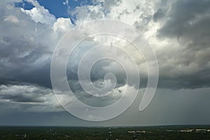 Landscape of dark ominous clouds forming on stormy sky before heavy thunderstorm over rural town area