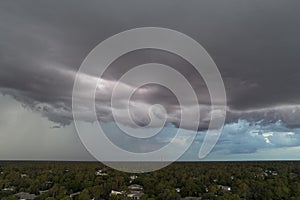 Landscape of dark ominous clouds forming on stormy sky before heavy thunderstorm over rural town area