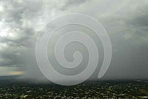 Landscape of dark ominous clouds forming on stormy sky during heavy thunderstorm over rural town area