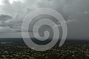 Landscape of dark ominous clouds forming on stormy sky during heavy thunderstorm over rural town area